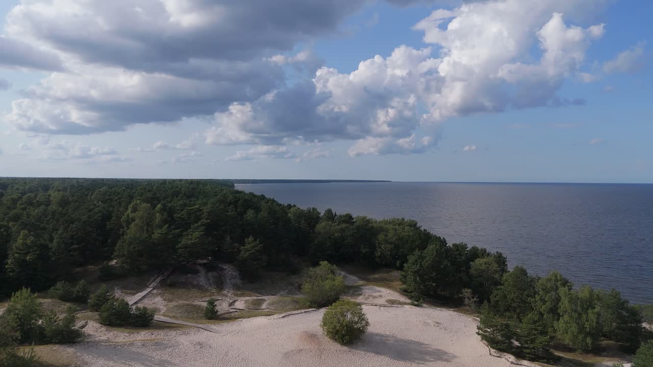 Aerial Drone Footage of Plienciems White Dune in Latvia on a Sunny Summer Day. Scenic Baltic Sea Bay Views, Peaceful Nature, and Coastal Landscape Captured in Cinematic Quality