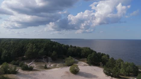 aerial drone footage of plienciems white dune in latvia on a sunny summer day. scenic baltic sea bay views, peaceful nature, and coastal landscape captured in cinematic quality
