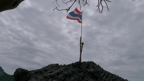 Thai-flag-fluttering-on-the-rock,-Thailand