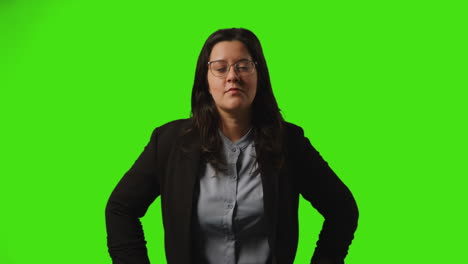 studio portret van zakenvrouw met een bril die tegen een groene achtergrond staat