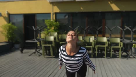 woman practicing yoga outdoors on a rooftop