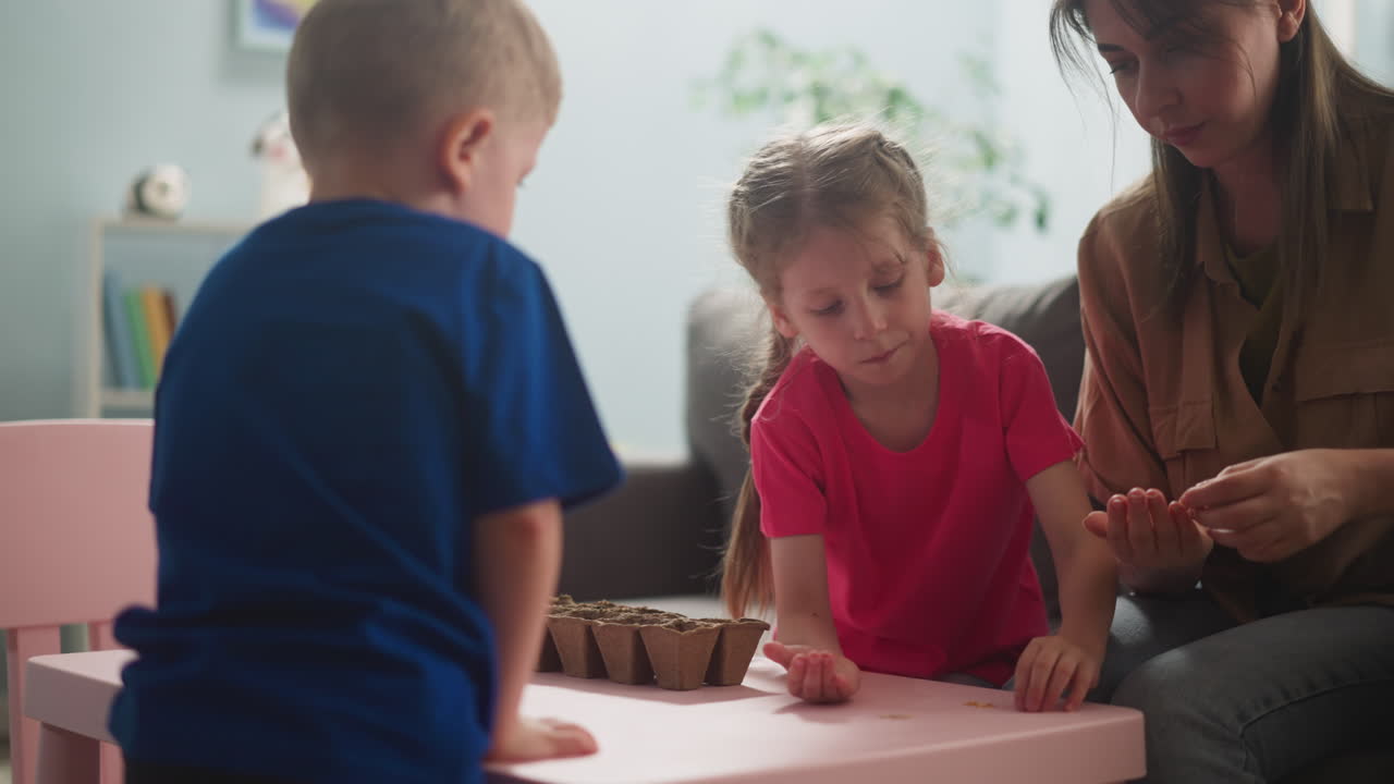 la niña toma semillas con la madre y el hermano en la sala de estar