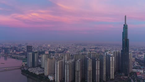 drone counter clockwise orbit of central park development, landmark, saigon river and city skyline in the early morning before sunrise