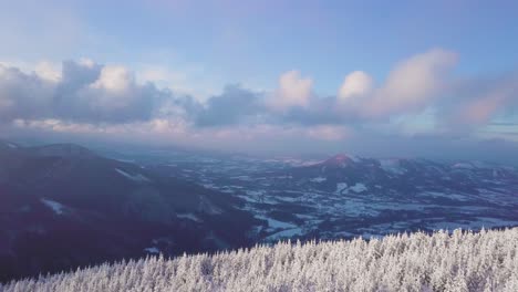 Celadna-in-the-distance,-flying-above-frozen-trees-towards-the-clouds-in-Beskydy-mountains,-UHD-or-4k,-30fps