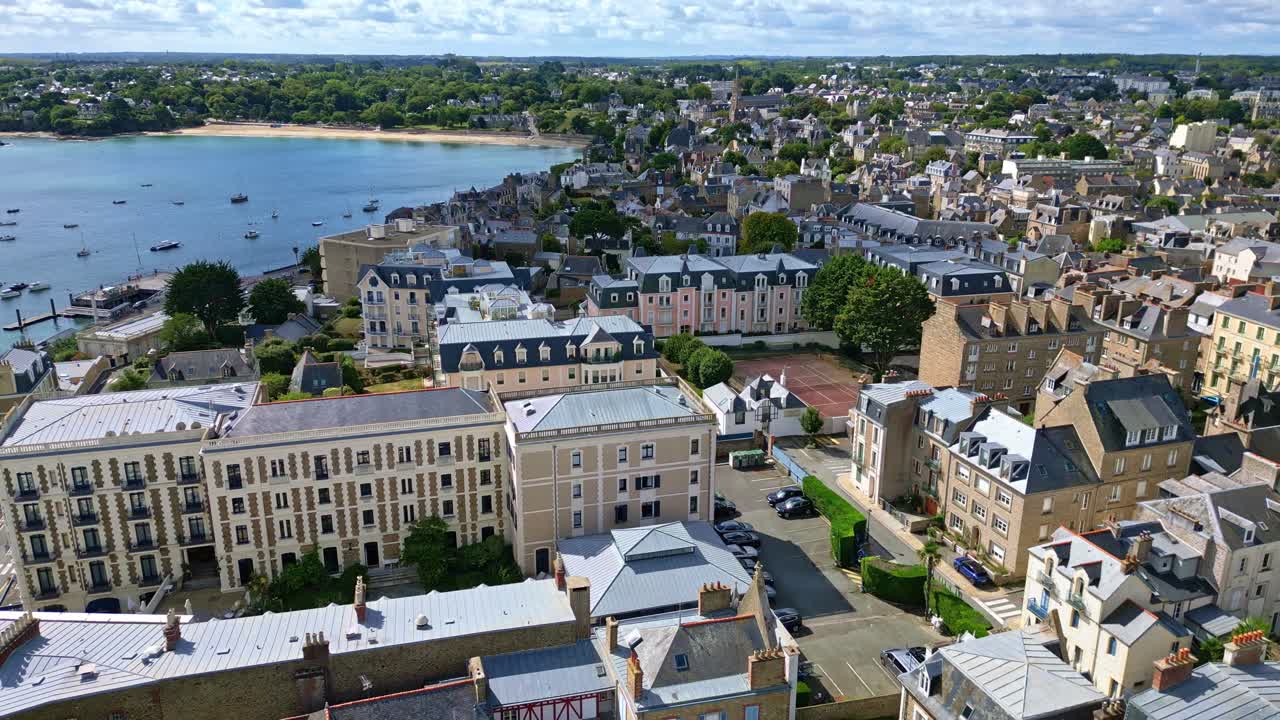 Smooth backward drone fly over the Dinard commune with bay view and clustered houses along waterfront, Ille-et-Vilaine, France