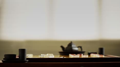 chinese tea set and glass chinese chess on the golden chess board