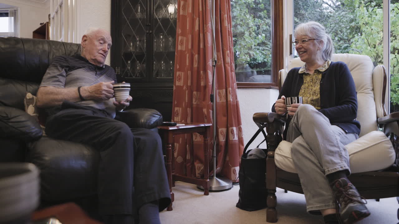 Elderly couple relaxing and conversing in their living room