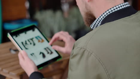 Man Browsing Online Shopping App on Tablet