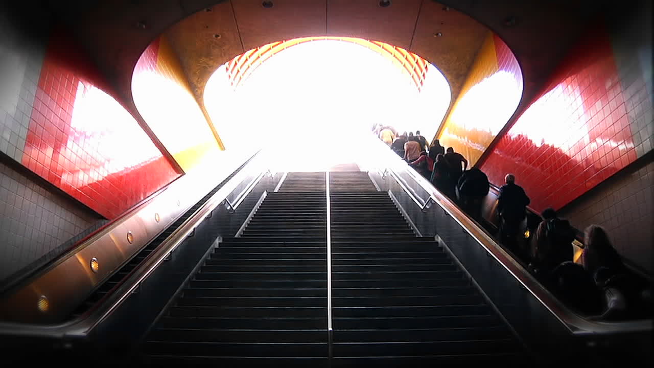 사람들은 지하철역에서 계단과 에스컬레이터를 통해 오르내립니다.