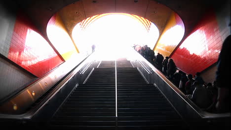 las personas ascienden y descienden por escaleras y escaleras mecánicas en una estación de metro