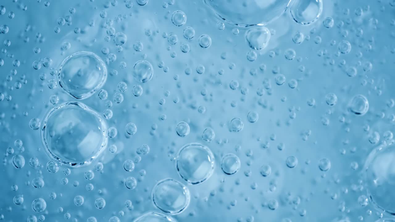 Bolle di ossigeno nell'acqua su uno sfondo blu astratto in super slow motion