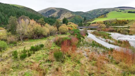 aerial view of a serene river winding through lush greenery and hills at lake tekapo, captured in natural daylight
