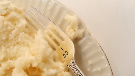 tenedor de boda grabado con &quot;sí quiero&quot; con pastel de boda blanco