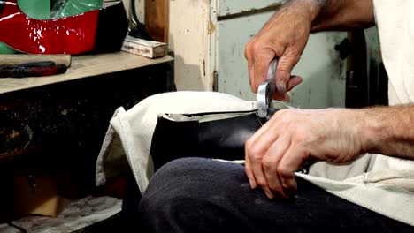 professional shoemaker using hammer while making new shoes