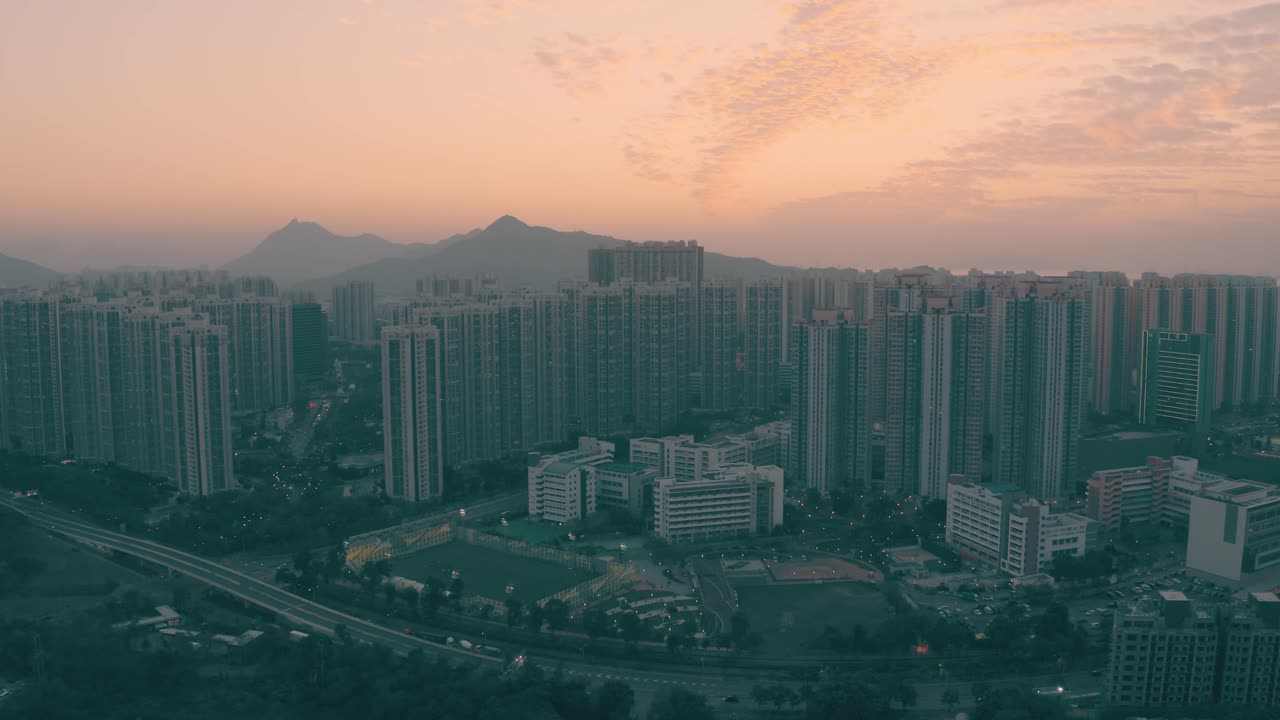 drone view of a public housing area during sunset with some mountain behind that gives a cinematic look