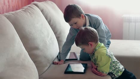 dos hermanos jóvenes jugando a la tableta pc