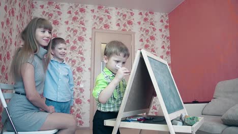 Younger brother is writing on the blackboard 1