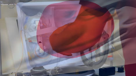 animación de la bandera de japón ondeando, sección media de un hombre biracial quitando equipo médico