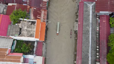 boats travel down narrow, dirty canal past dilapidated buildings