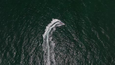 extreme jet boat roaring across the sea with tourists, aerial footage