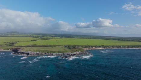 panorámica aérea que establece la costa cerca de hookipa maui tierras bajas inclinadas en un día soleado