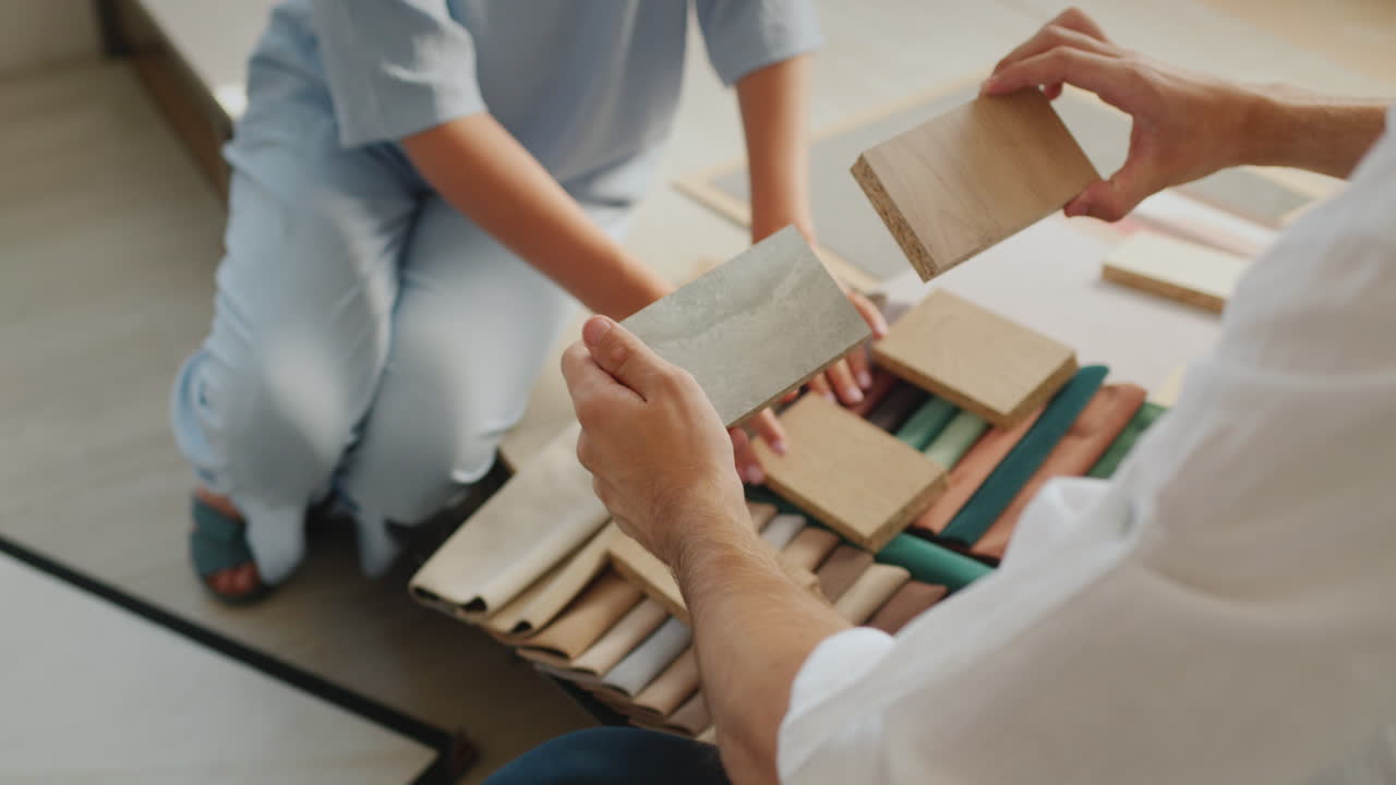 두 배우자가 집을 마무리하기 위해 나무, 직물, 벽지  ⁇ 플을 살펴봅니다.