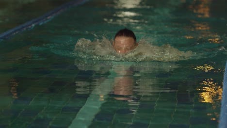 person swimming in a dark pool at night