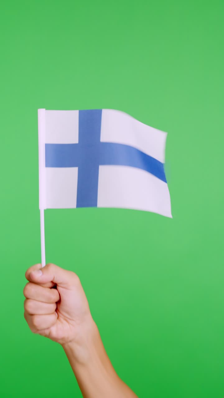 Hand lifting a finnish pennant while waving by the wind