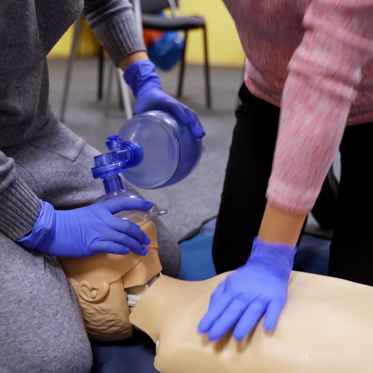 Medical practice to save life. Students in medical gloves learning to do a cpr on a dummy in training center. Adult cpr training and first aid