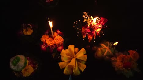 loy krathong festival: top-down close-up shot of colorful krathongs floating on the water