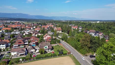 Drone-flight-with-a-DJI-drone-over-the-fields-towards-the-beautiful-reformed-church-from-1664-in-Bätterkinden-and-the-cemetery-near-Bern-in-Switzerland