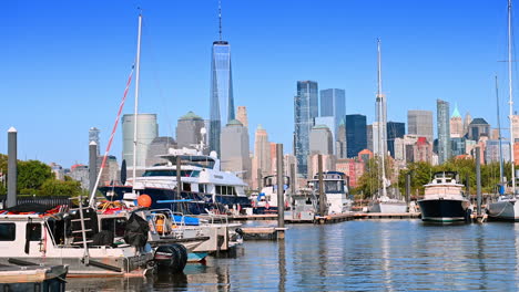 footage near the pier with boats and yachts anchored by. majestic skyscraper skyline at backdrop