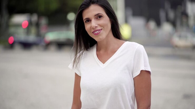 una joven morena sonriente posando en la calle