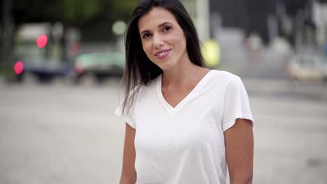 smiling young brunette posing on street