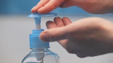 a woman presses the dispenser and liquid soap squeezed out in her hand is shot in close-up on a white background