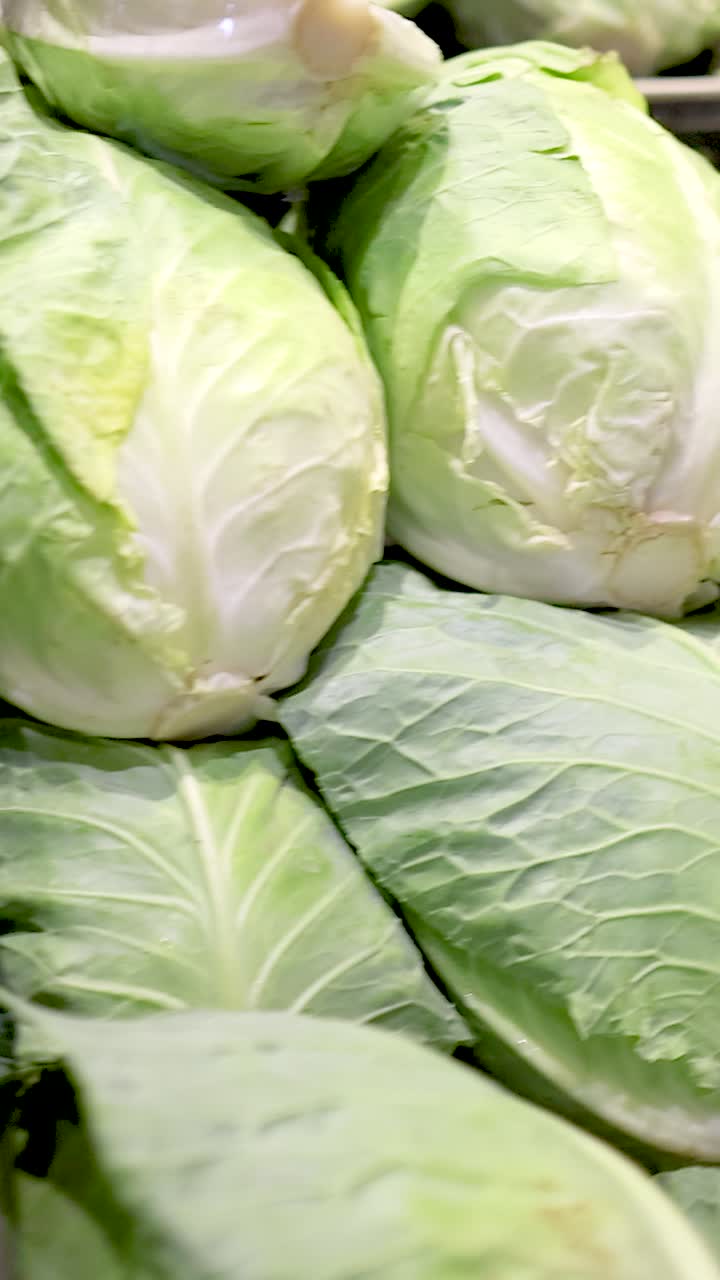 Vibrant vegetables including broccoli, cauliflower, and cabbage arranged under bright lighting in a supermarket setting
