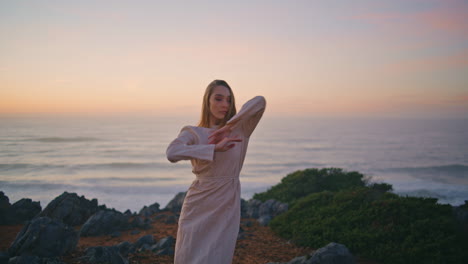 flexible girl performing dance on evening sea coast. woman dancing choreography