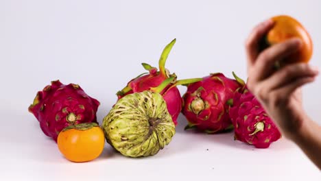 hands selecting fruits from a colorful arrangement