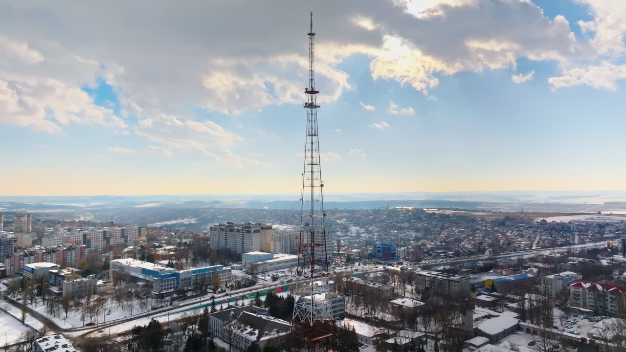 Aerial drone view of the radio transmission tower in the daylight. Ground covered in snow in Chisinau, Moldova
