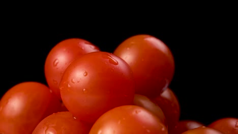 tomates de cereza frescos sobre un fondo negro