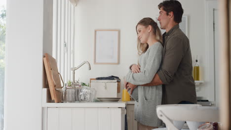 feliz pareja embarazada abrazando orgulloso marido abrazando a su esposa sosteniendo su vientre emocionado por los padres mirando por la ventana pensando en el futuro 4k
