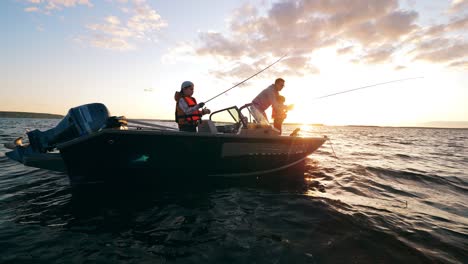 dos niños están pescando con su padre desde un velero