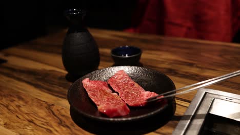 slicing and grilling beef slices on a mesh grill