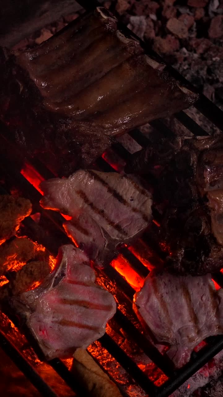 Mano volteando carne en una parrilla caliente