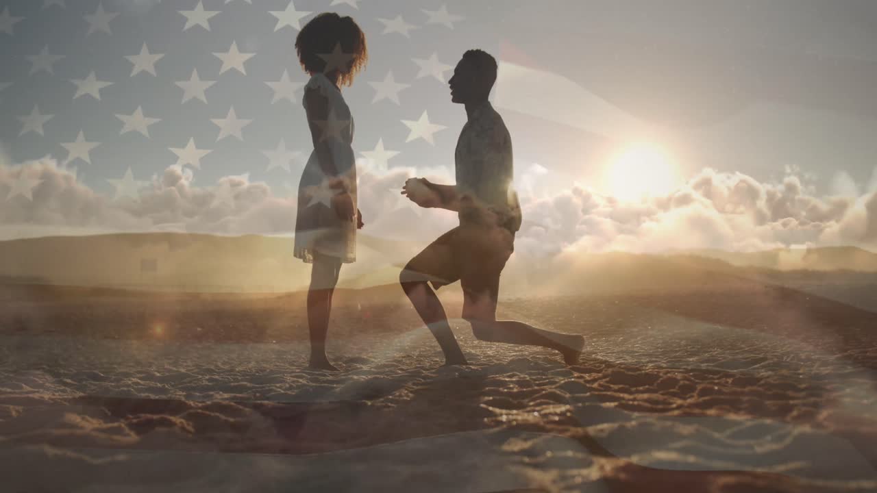animación de la bandera de los estados unidos de américa sobre un hombre biracial proponiéndole a su novia en la playa