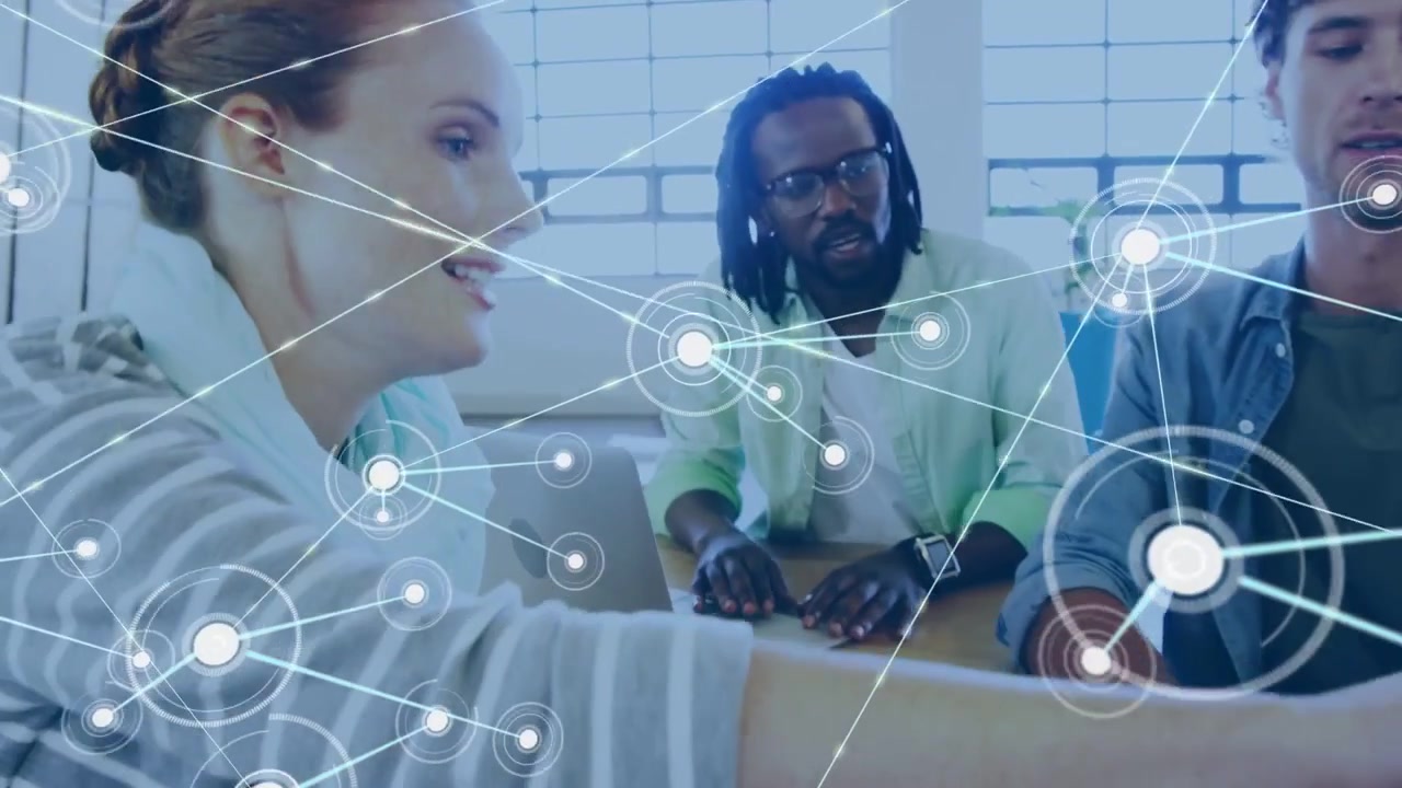 Man presenting tablet, spurring peer typing, network overlay linking laptops for tech teamwork