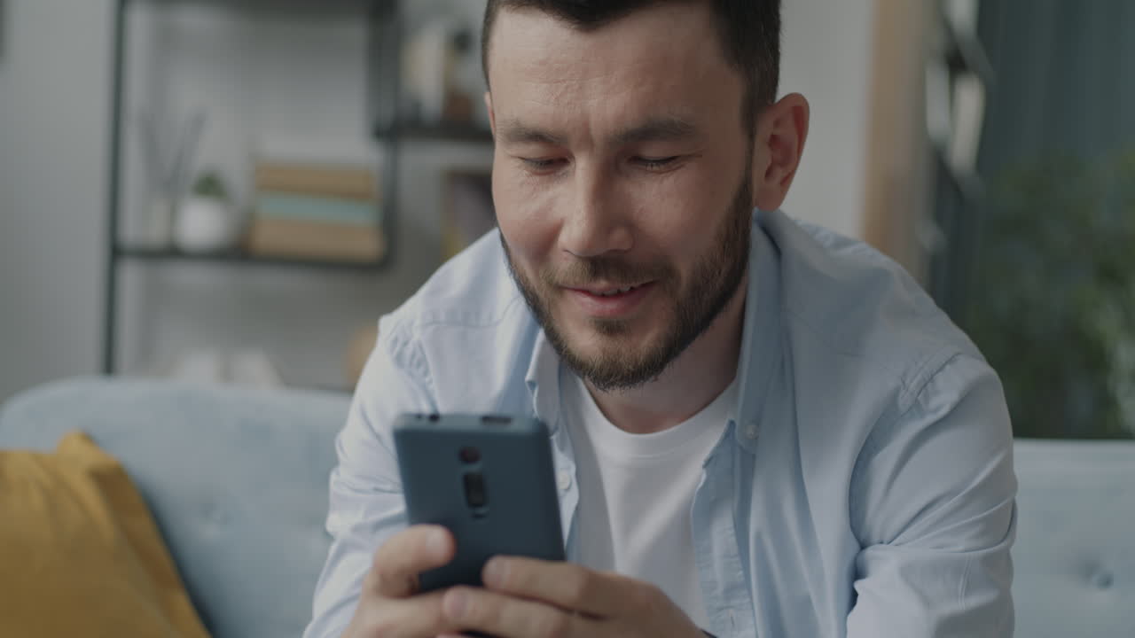 집에서 스마트폰을 사용하는 남자