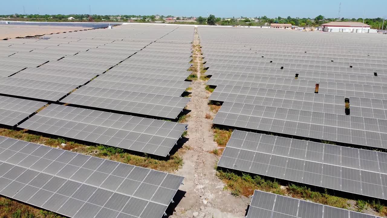 Rare aerial ascension overview of African solar farm for sustainable renewable energy but with very dirty dusty solar panel arrays