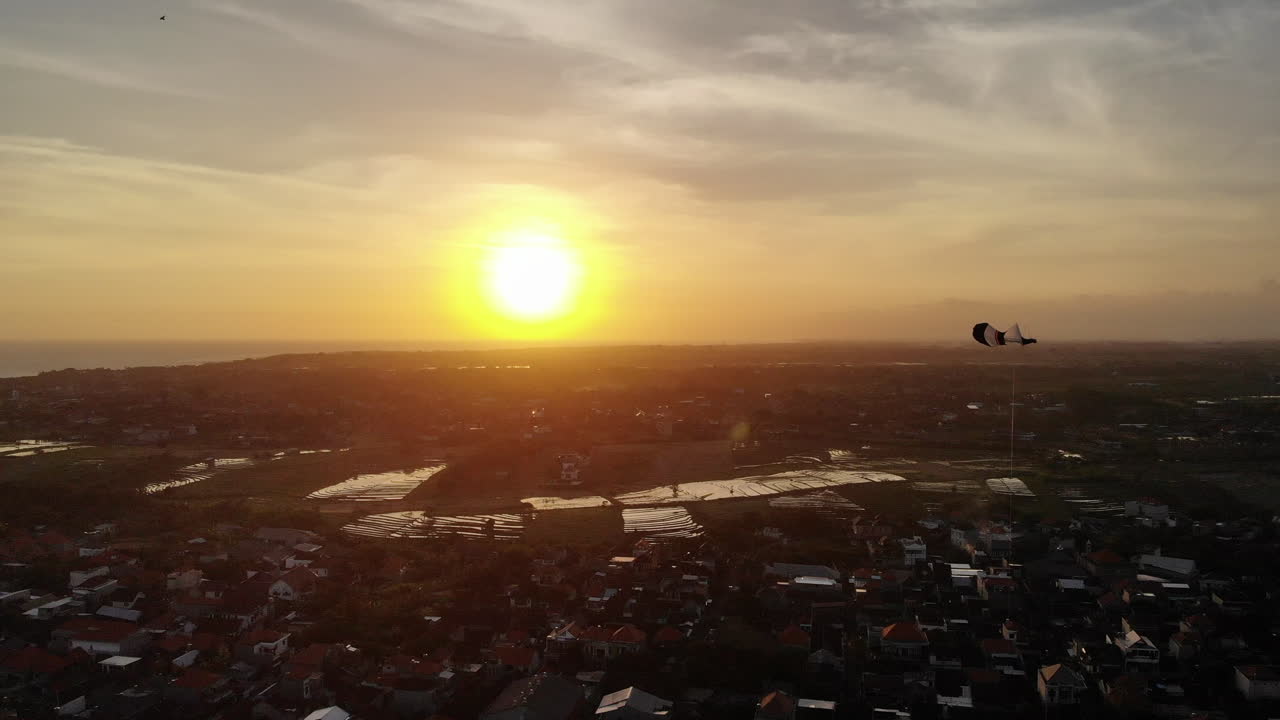 놀라운 일몰에 즐겁게 날아가는 화려한 연에 가까이 날아갑니다.