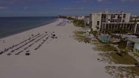 4K-Drone-Video-of-Beach-Cabanas,-Umbrellas,-and-Waterslide-on-the-Gulf-of-Mexico-in-St